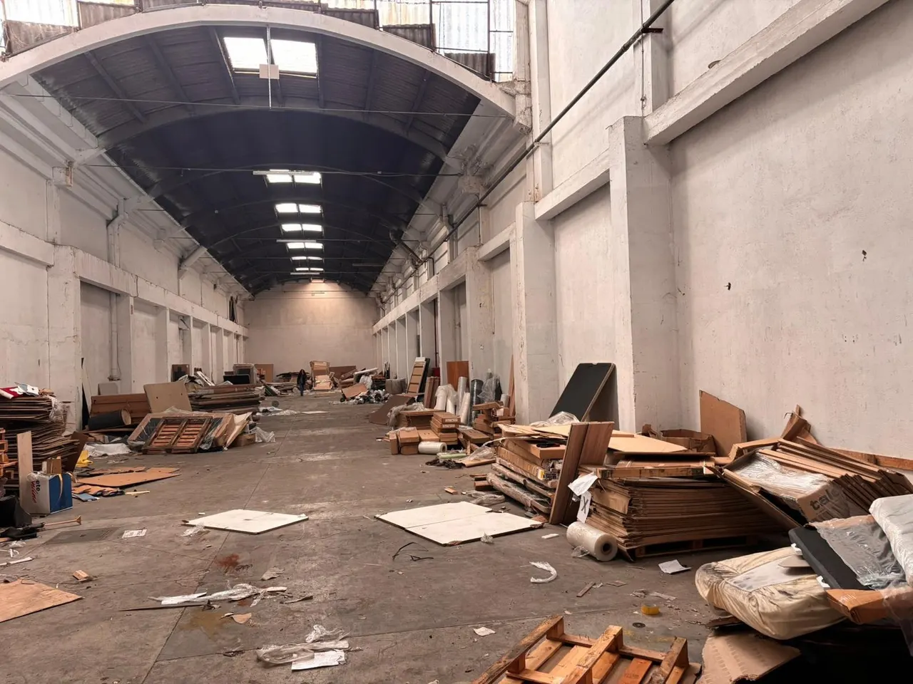 Nave industrial en Barcelona antes del vaciado, con palés, cartón y material acumulado por todo el suelo