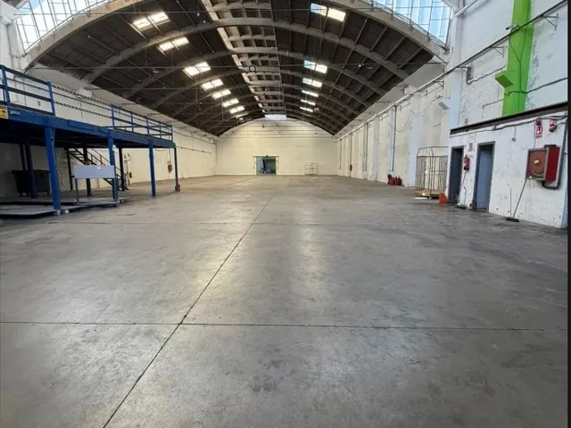 La misma nave industrial después del vaciado, completamente despejada y limpia